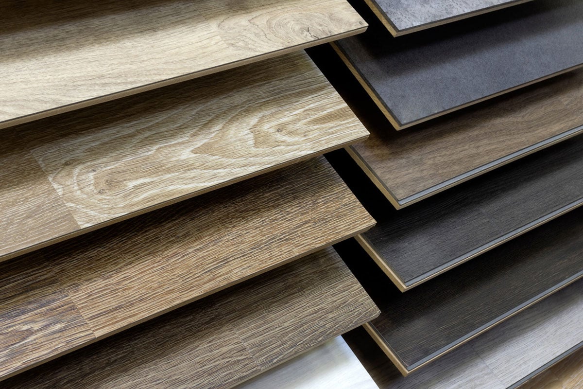 Several samples of waterproof flooring are displayed in rows, showcasing a variety of wood grain patterns and colors, ranging from light tan to dark brown and gray. Several samples of waterproof flooring are displayed in rows, showcasing a variety of wood grain patterns and colors, ranging from light tan to dark brown and gray.