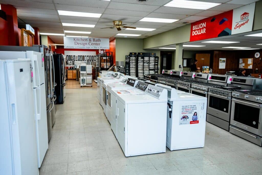 Washing machines and ovens on display in a store. Various home appliances for sale.