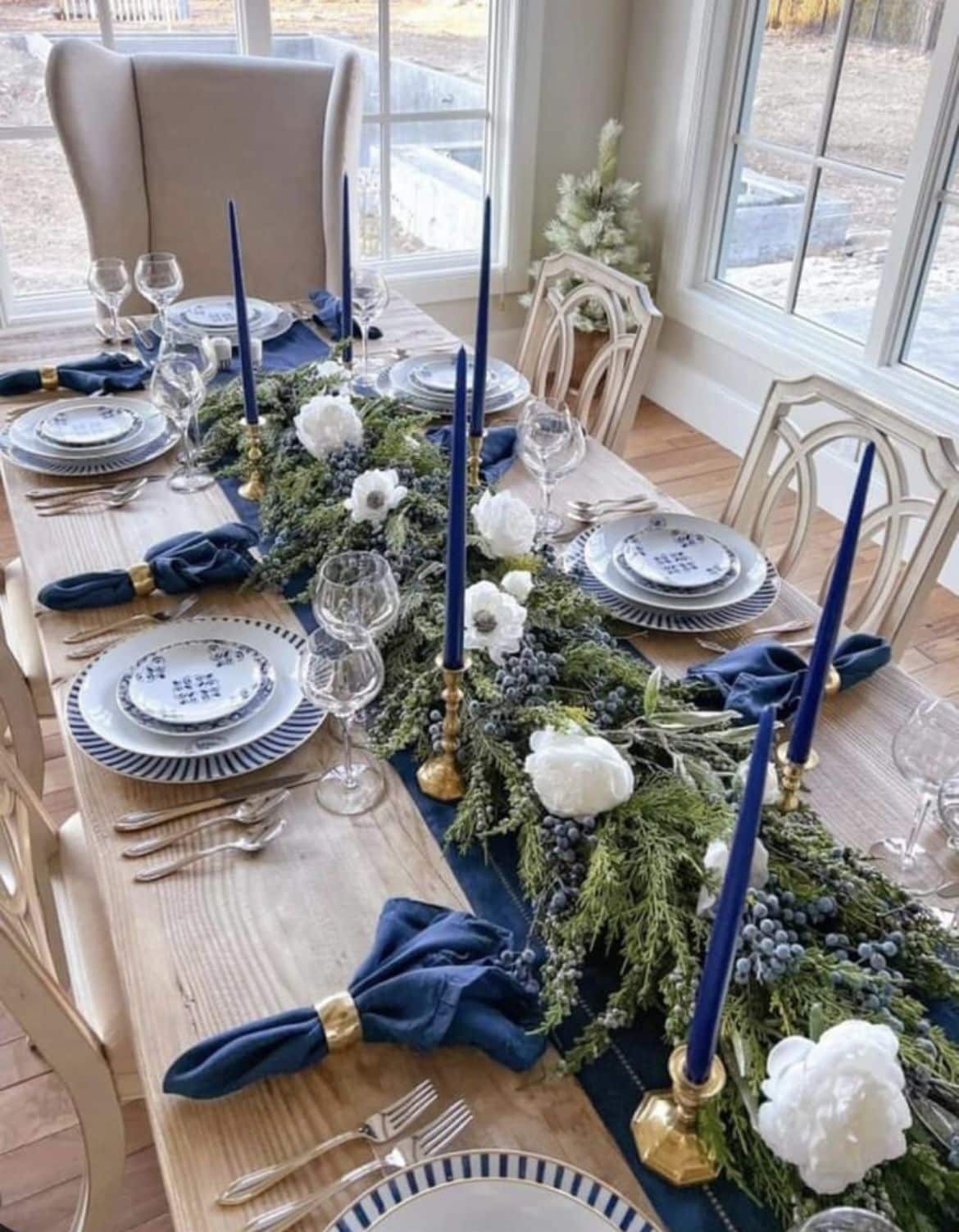 A beautifully set dining table with blue candles and flowers