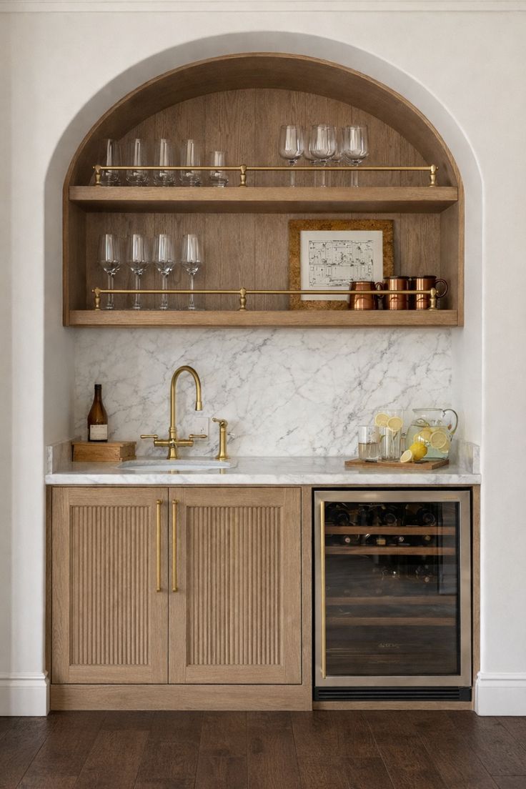 A modern wet bar with a wine fridge, sink, and gold fixtures.