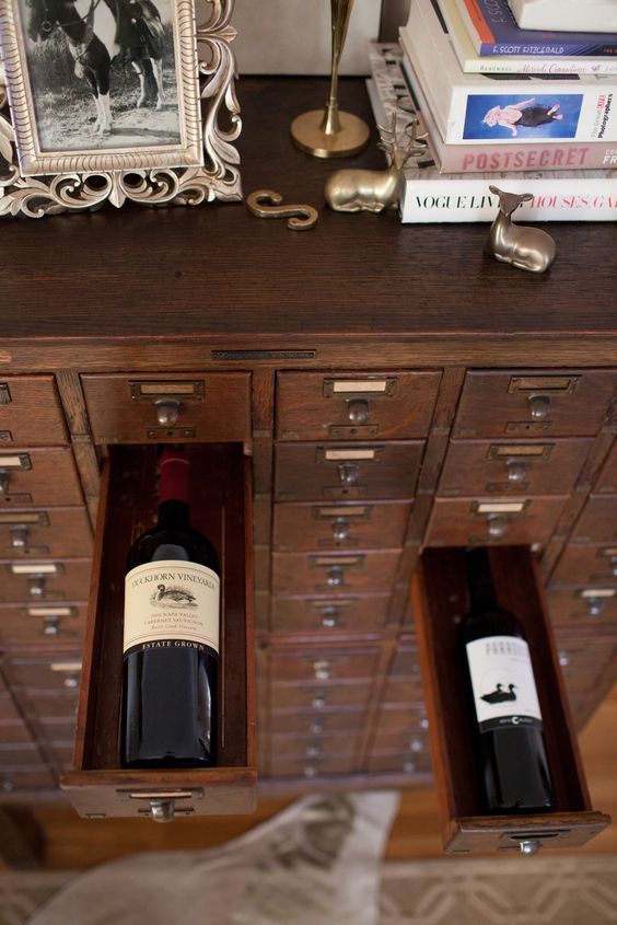Two wine bottles stored in a wooden drawer.