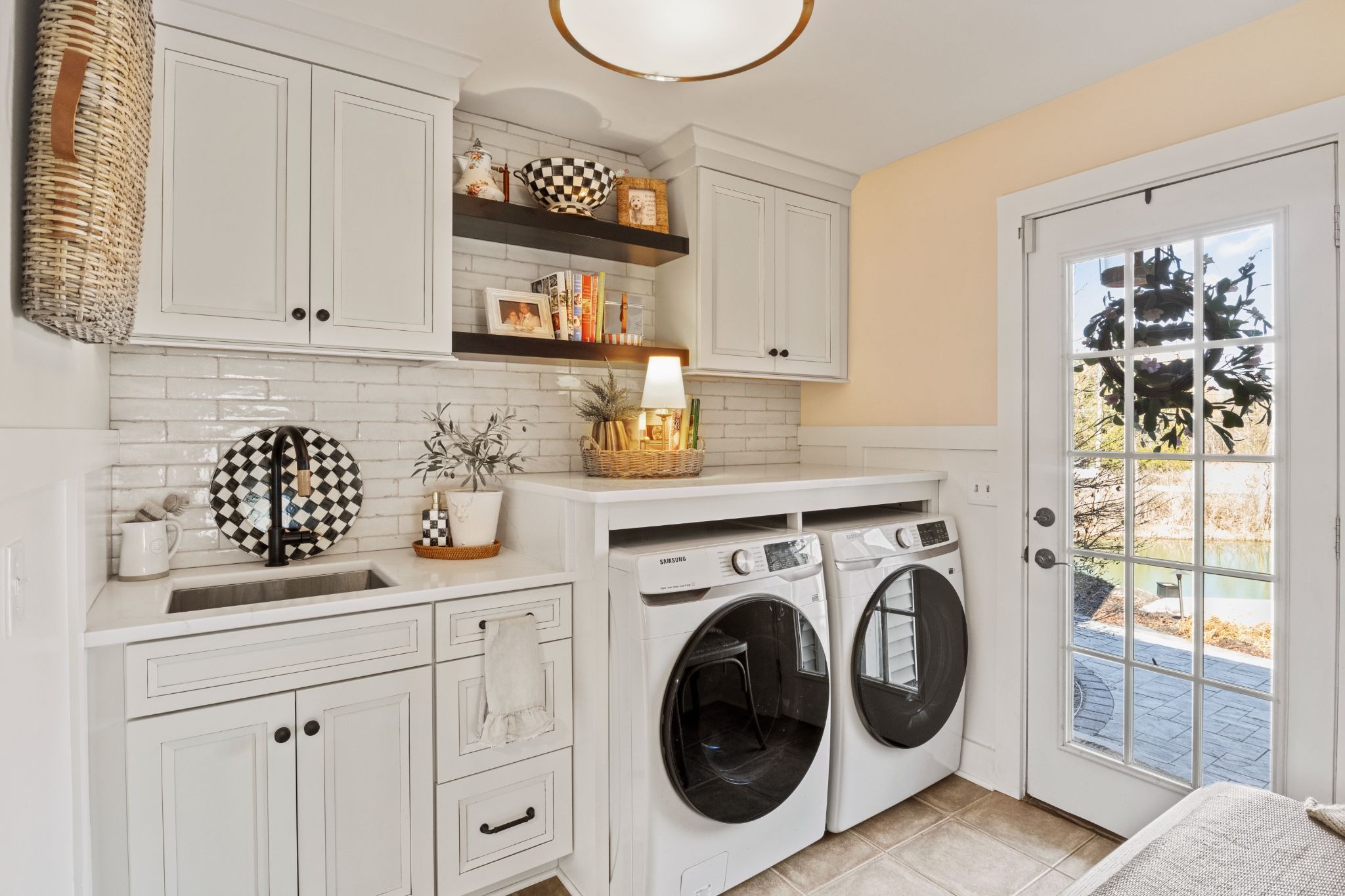 Laundry room with front loading washer and dryer. White cabinets and countertop.