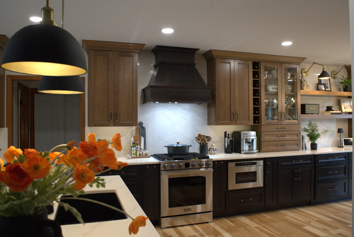 A modern kitchen with white countertops, dark wood cabinets and orange flowers on the island.