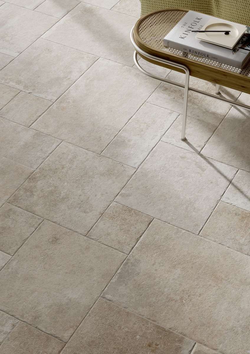 Beige tile flooring. A chair with books on it.