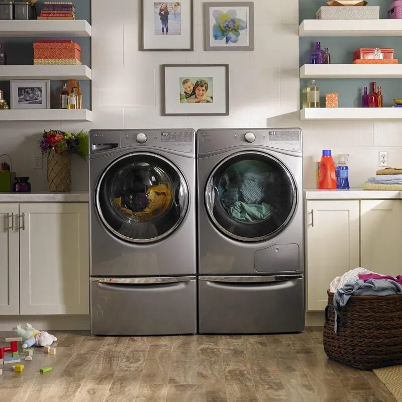 Laundry room with washer and dryer, baskets on the floor.