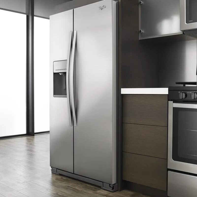 A stainless steel refrigerator and oven in a modern kitchen.
